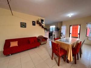 sala de estar con sofá rojo y mesa en Casa de Huéspedes Paola, en Puerto Baquerizo Moreno