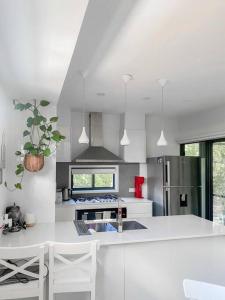 a white kitchen with a sink and a refrigerator at Quite 2B2B Family Home w free parking, BBQ in Brisbane