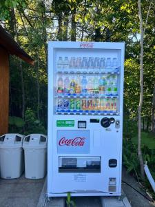 een cocacola koelkast gevuld met flessen frisdrank bij Shirakaba no mori Cottage - Vacation STAY 90794v in Abashiri