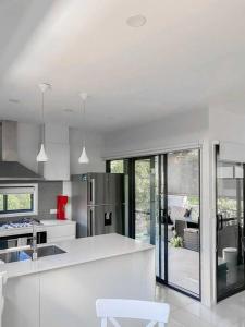 una cocina blanca con encimera blanca y electrodomésticos en Quite 2B2B Family Home w free parking, BBQ, en Brisbane
