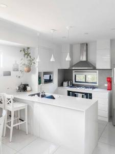 a white kitchen with a counter and a stove top oven at Quite 2B2B Family Home w free parking, BBQ in Brisbane