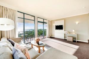 - un salon avec un canapé et une table dans l'établissement Oceanview Corner - Resort-like Living with Pool, à Darwin