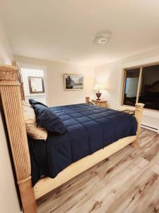 1 dormitorio con 1 cama con edredón azul en Nature Lovers’ Paradise, en Nanaimo
