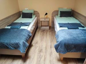dwa łóżka siedzące obok siebie w pokoju w obiekcie Restauracja "AS"- Noclegi w mieście Turek