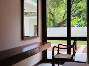 Habitación con escritorio, silla y ventana. en Lake Round Luxury House en Kurunegala