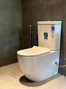 een wit toilet in een badkamer met een muur bij Lake Round Luxury House in Kurunegala