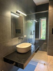 a bathroom with a large bowl sink on a black counter at Lake Round Luxury House in Kurunegala