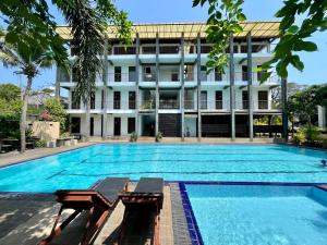 a large swimming pool in front of a building at Olanro Hotel Negombo in Negombo