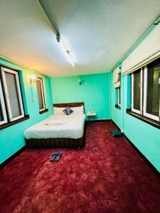 a bedroom with a bed and a red carpet at Heranya Hostel in Kathmandu