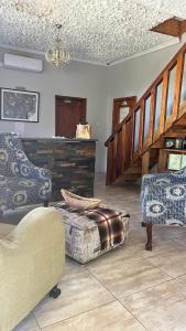 a living room with two chairs and a staircase at PLANES in Kokstad