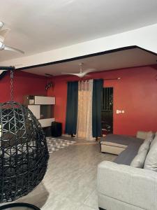 un soggiorno con divano e parete rossa di Le bonheur a Dzaoudzi