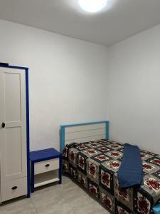 una camera con letto, comodino e letto sidx sidx sidx. di Le bonheur a Dzaoudzi