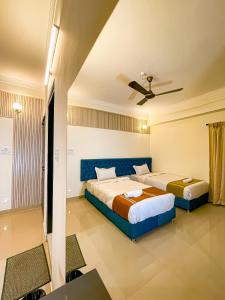 a bedroom with two beds and a ceiling fan at Irroi Guwahati in Guwahati