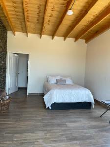 um quarto com uma cama e um tecto de madeira em Canto Rodado Valle de Guadalupe em Ensenada