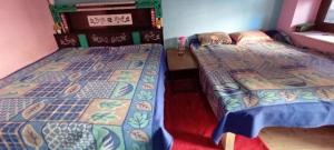 twee bedden in een kleine kamer met bij Bhumika Home Stay in Kapkot