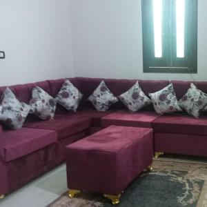 a purple couch with pillows on it in a room at Nubian Queen Guest House in Aswan