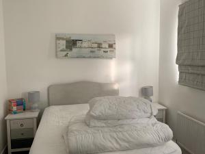 um quarto com uma cama com lençóis brancos em Captivating 3-Bed Cottage in Port na Blagh em Port na Bláiche