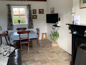 a living room with a table and a tv at Captivating 3-Bed Cottage in Port na Blagh in Port na Bláiche