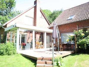 ein Haus mit einer Terrasse und einem Sonnenschirm in der Unterkunft Holiday home Heinrich in Kappeler Niederstrich