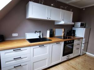 a kitchen with white cabinets and a sink and a refrigerator at Sophienhof Lieselotte in Neuenkirchen +33 photos