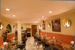 パタヤ・サウスにあるBaan Souy Resortのテーブルと椅子が備わるレストラン