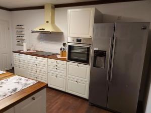 a kitchen with a stainless steel refrigerator and white cabinets at Holiday house on Bornfeld in Leimen