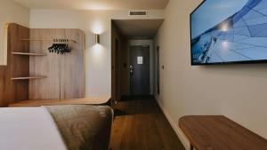 una stanza con una TV a schermo piatto su una parete di Keystone Hôtel & Spa a Lione Altre 90 foto