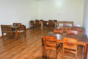 un grupo de mesas y sillas en una habitación en Ranthambhore Nature Farm, en Sawāi Mādhopur