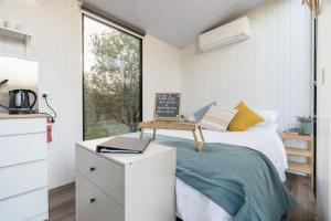 een slaapkamer met een bed, een bureau en een raam bij Olive Grove Retreat 1 in Lake Boga