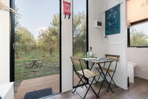 een kamer met een tafel en stoelen en een raam bij Olive Grove Retreat 1 in Lake Boga