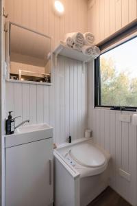 een witte badkamer met een wastafel en een spiegel bij Olive Grove Retreat 1 in Lake Boga