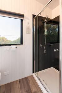 een badkamer met een douche en een glazen deur bij Olive Grove Retreat 1 in Lake Boga