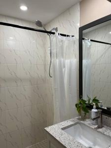 a white bathroom with a shower and a sink at Bernie's Basement in Milton +28 photos