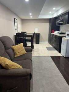 a living room with a couch and a kitchen at Bernie's Basement in Milton