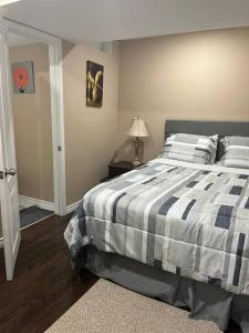 a bedroom with a bed with a black and white comforter at Bernie's Basement in Milton
