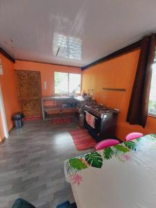 a living room with orange walls and a stove at Marupo Room in Fare