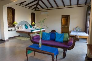 Shenandoah Kandy في كاندي: غرفة معيشة مع أريكة أرجوانية وسريرين