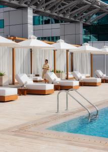 a woman in a dress standing next to a swimming pool at Jumeirah Living World Trade Centre Dubai in Dubai +42 photos