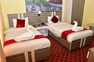 2 Betten mit Schwänen in einem Hotelzimmer in der Unterkunft Hotel Jiyan Hospitality Pvt. Ltd. in Dhangadhi