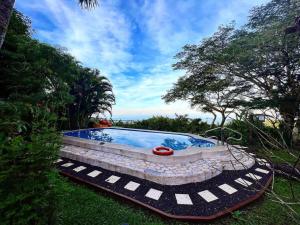una piscina en un patio con árboles y césped en El Mirador Glamping & Apartments & Woodhouse & Swimingpool en Miramar