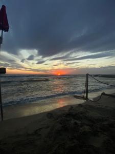 una puesta de sol en la playa con el océano en Casa Vacanze Manu, en Galatina