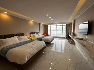 Habitación de hotel con 2 camas y TV de pantalla plana. en Luckytito Anilao Resort en Mabini