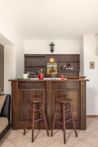 uma cozinha com um bar de madeira com dois bancos em Apartman Lavanda em Kostrena