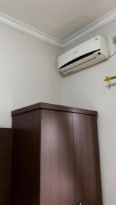 a room with a ceiling fan and a wooden cabinet at Hens Guesthouse Syariah in Gadobangkong