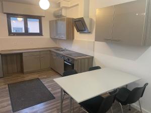 a kitchen with a white table and a table and chairs at Appartement 50M² in Seltz