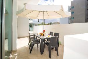 een eetkamer met een tafel en een paraplu bij Calypso - Coralli Beachfront Apartment in Protaras