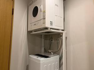 a microwave and a washer and dryer in a room at AO Dazaifu / Vacation STAY 61732 in Chikushino