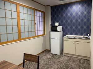 a kitchen with a white refrigerator and a sink at AO Dazaifu / Vacation STAY 61732 in Chikushino