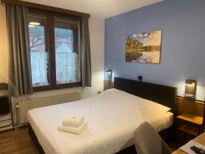 1 dormitorio con 1 cama con 2 toallas en Hotel Monika en Zutendaal
