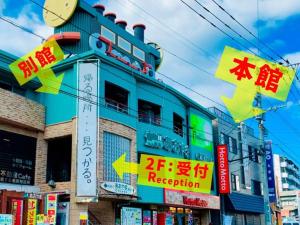 ein blaues Gebäude mit Schildern an der Seite in der Unterkunft AO Dazaifu / Vacation STAY 61720 in Chikushino